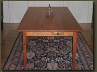 Our Cherry Dining Table has a small drawer which makes this good-looking table all the more functional