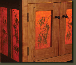This detail image of our Thread Leaf Sideboard shows the magnificent mica panels containing a branch of a Japanese Thread Leaf Maple tree. The hand-turned walnut pulls are attached with a wedged through-tenon.